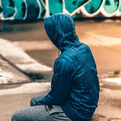 Teenager sitting near graffiti