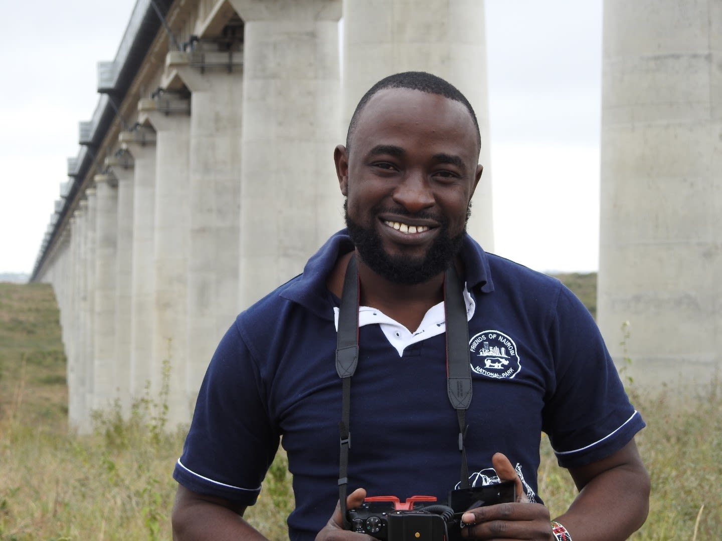 Nyandire Reinhard holding camera in front of railway line