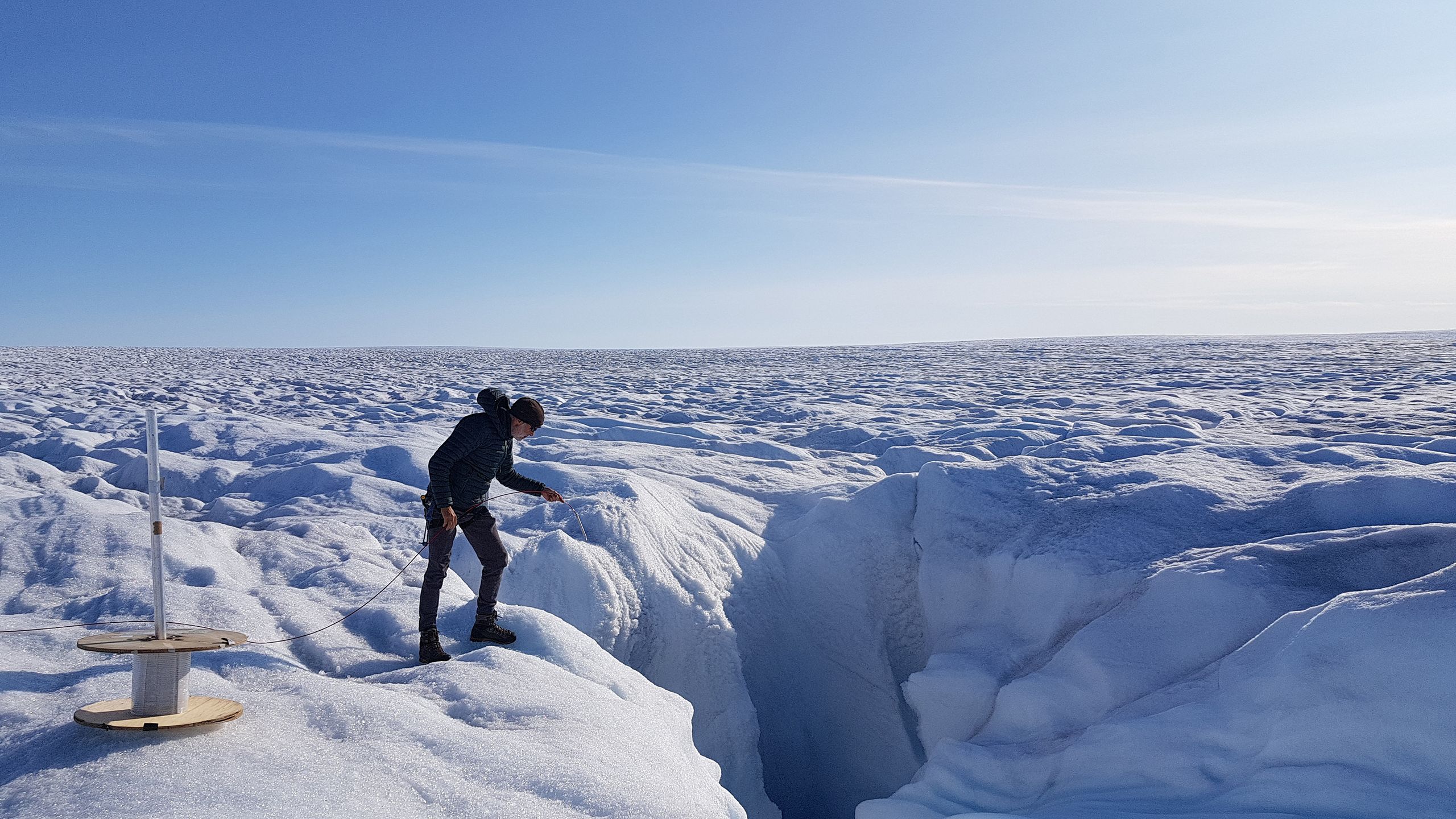 Scientist installs fibre-optic cable on the Greenland Ice Sheet