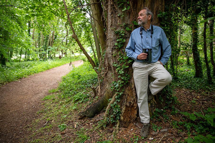Bill leaning against tree