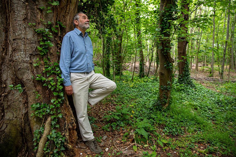 Bill leaning against tree