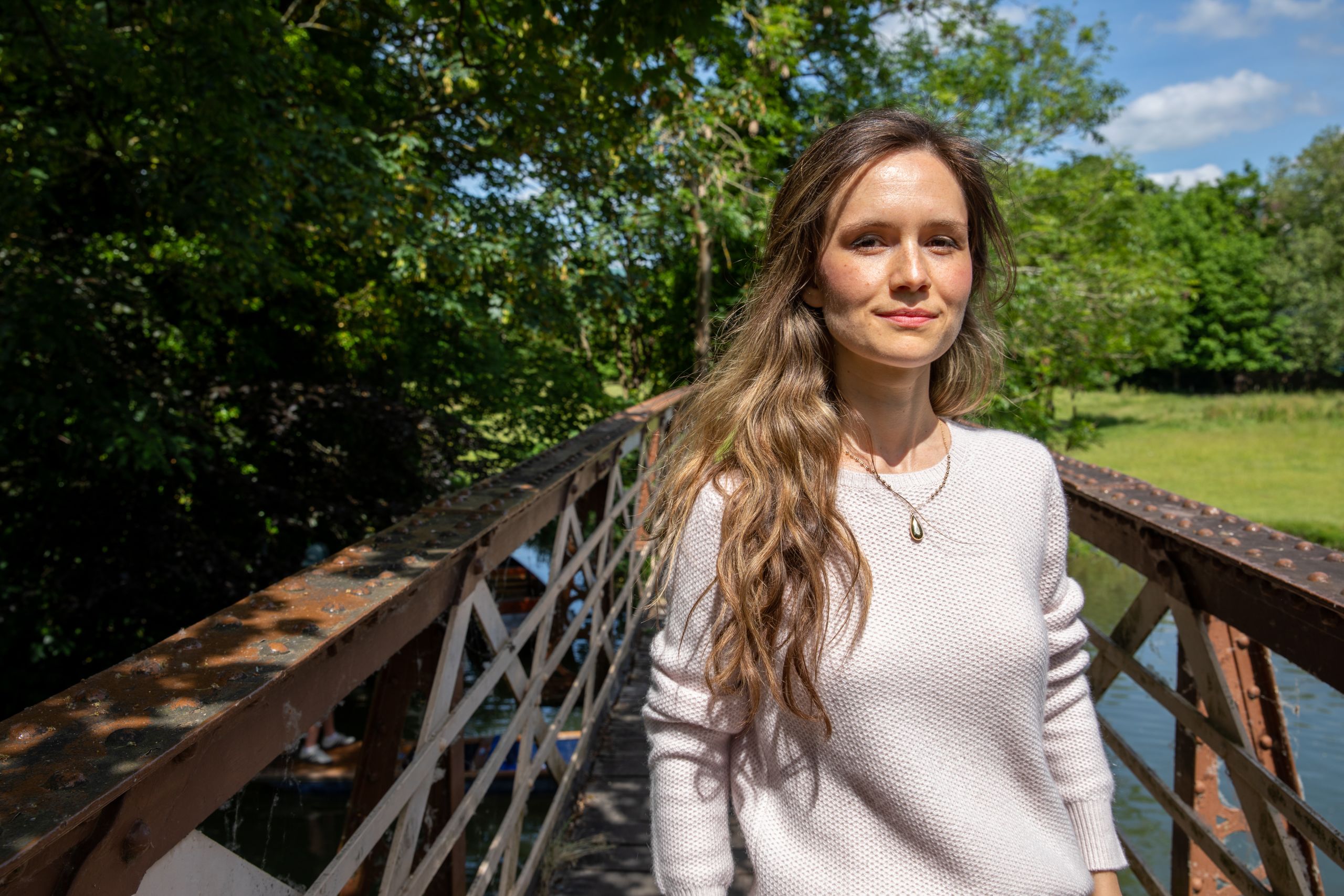 Olivia stands next to a bridge