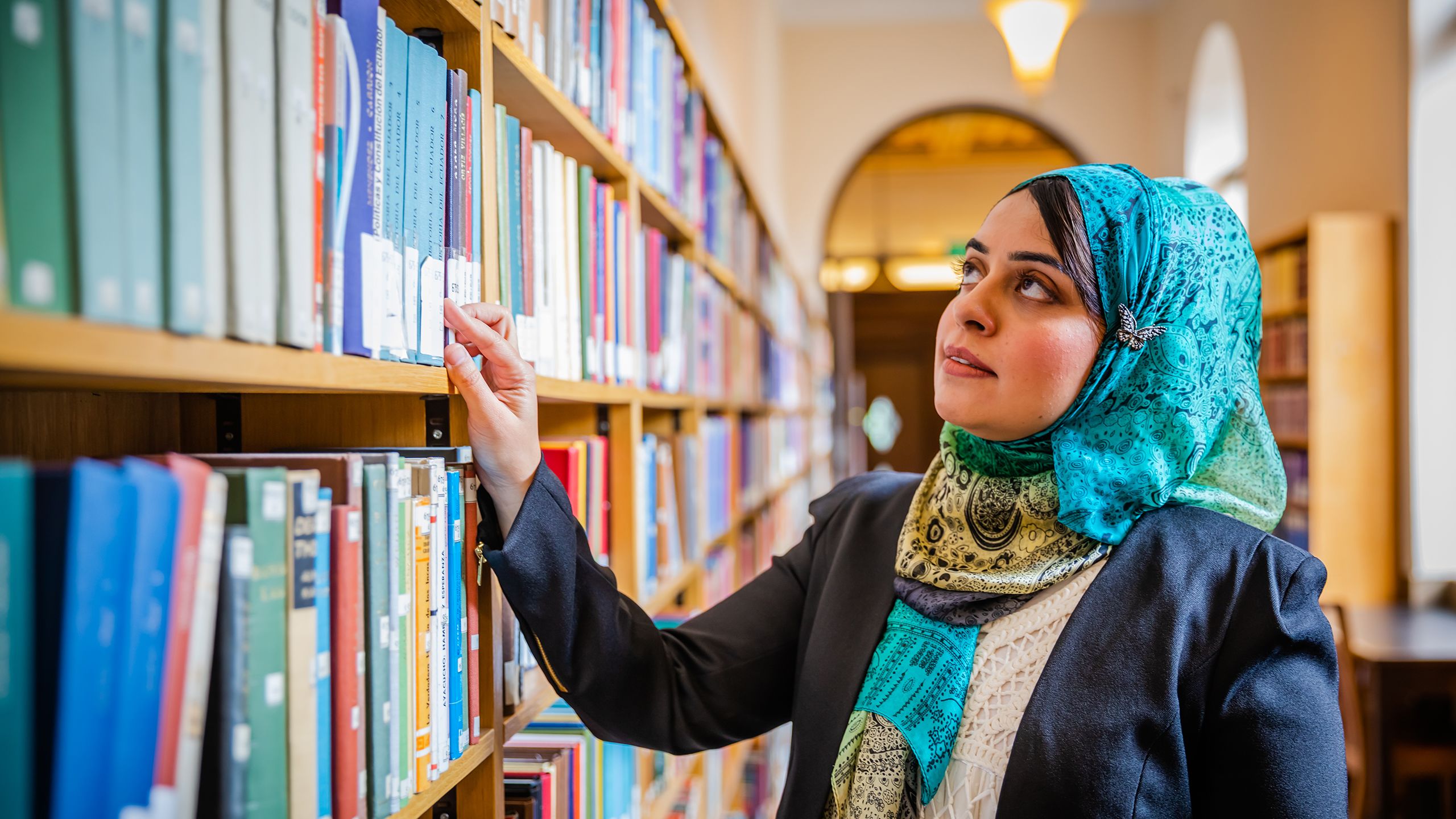 Rihab looking at bookshelves  