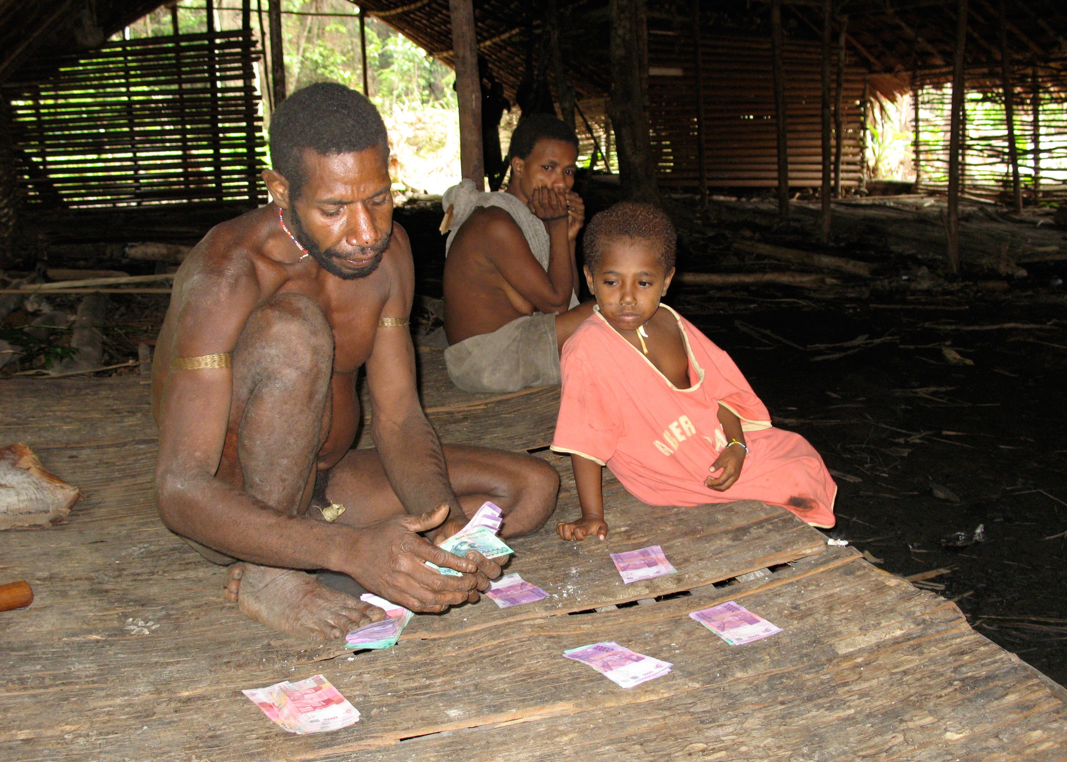 Yakop Dayo dividing out to his relatives the payment left by a Swiss film crew