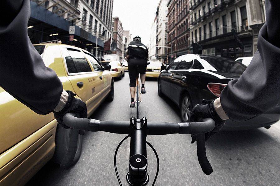 Bicycle courier in traffic, New York City. Credit: GibsonPictures/ Getty