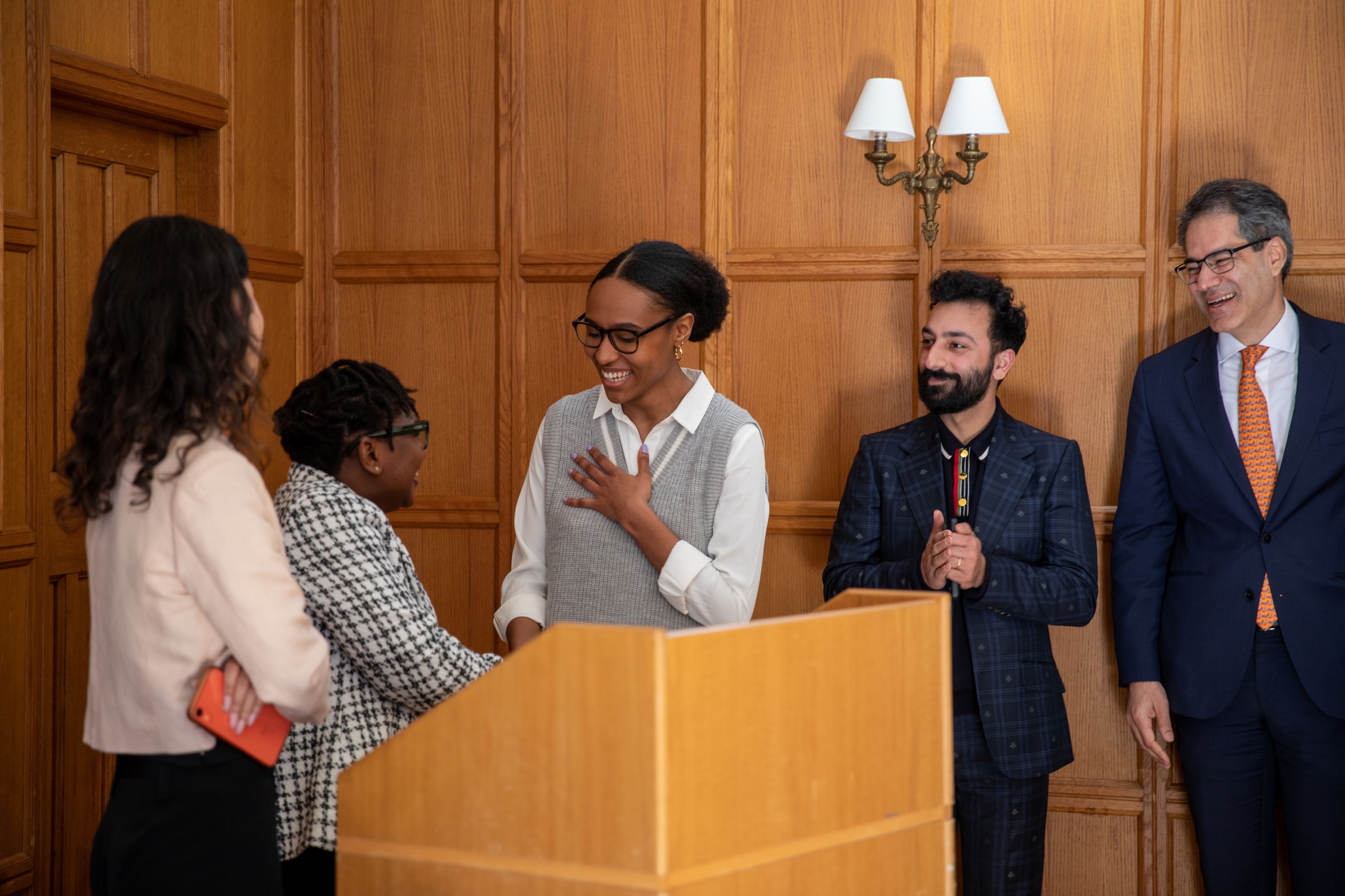 Maya McFarlane shaking hands with Rumbidzai Dube, others looking on