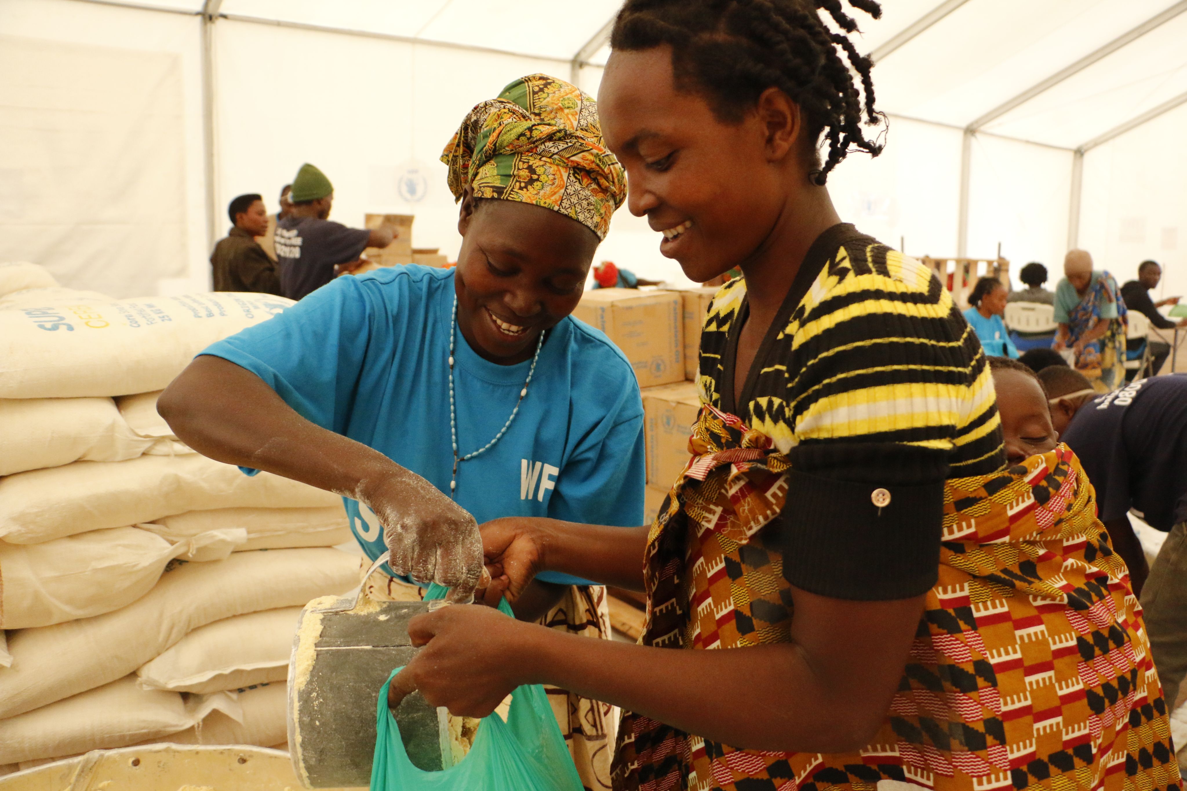 Maria receives her monthly entitlement of nutritionally fortified flour from WFP. Photos: WFP/Claire Nevill