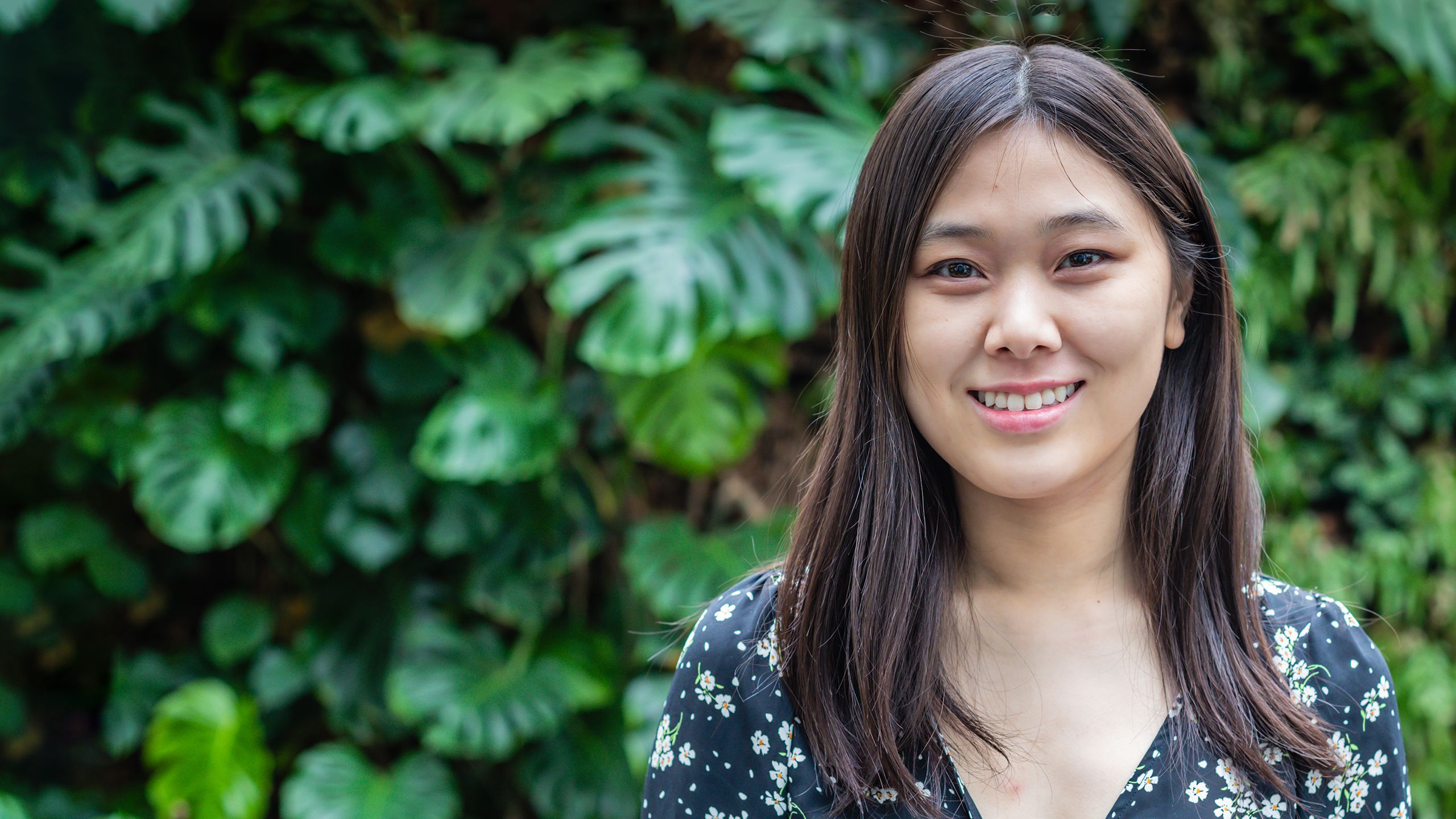 Clara Ma in front of the ‘living wall’ in the David Attenborough Building 