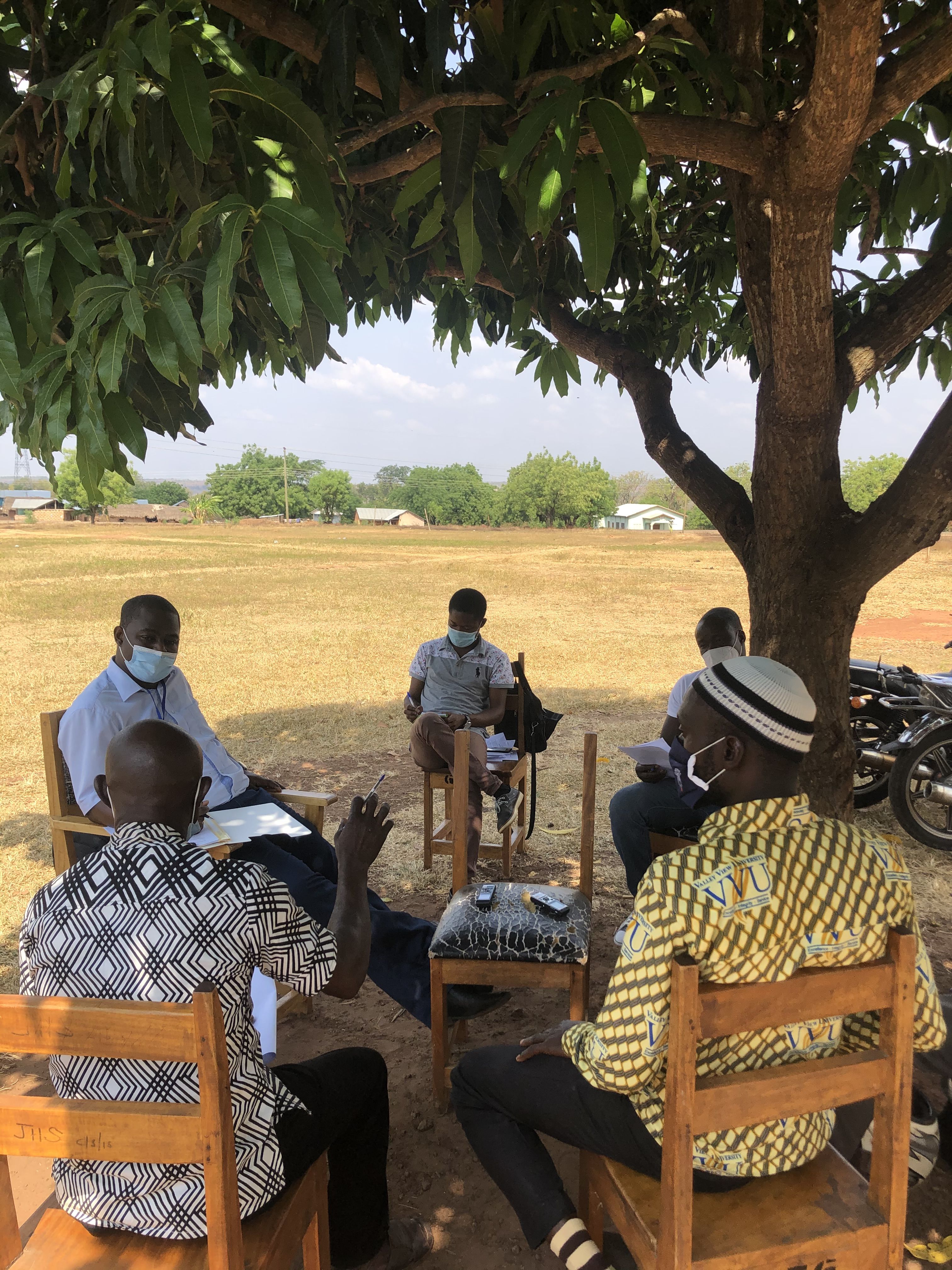 Teachers and researchers chatting under tree