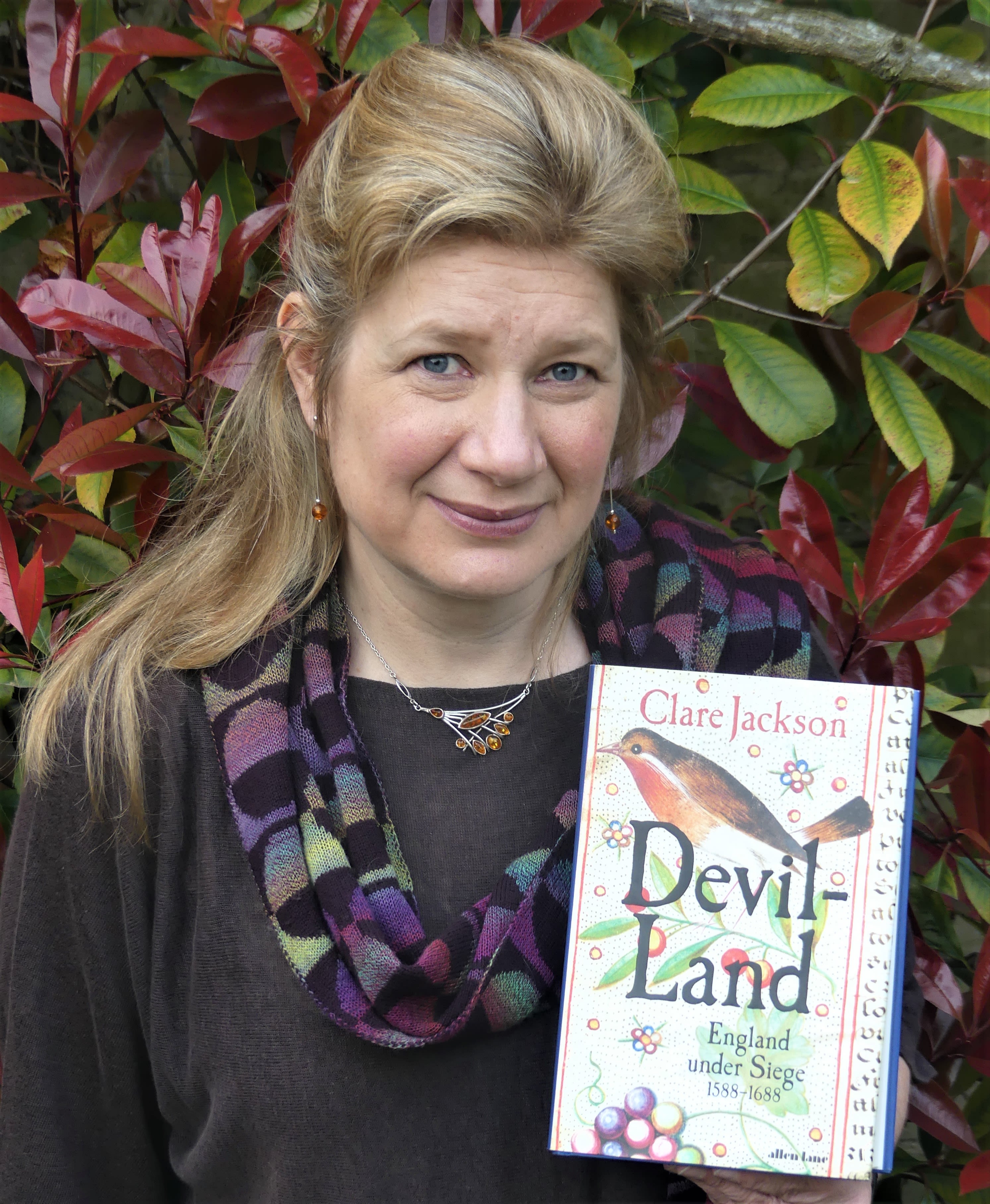 Dr Clare Jackson holding her book Devil-land