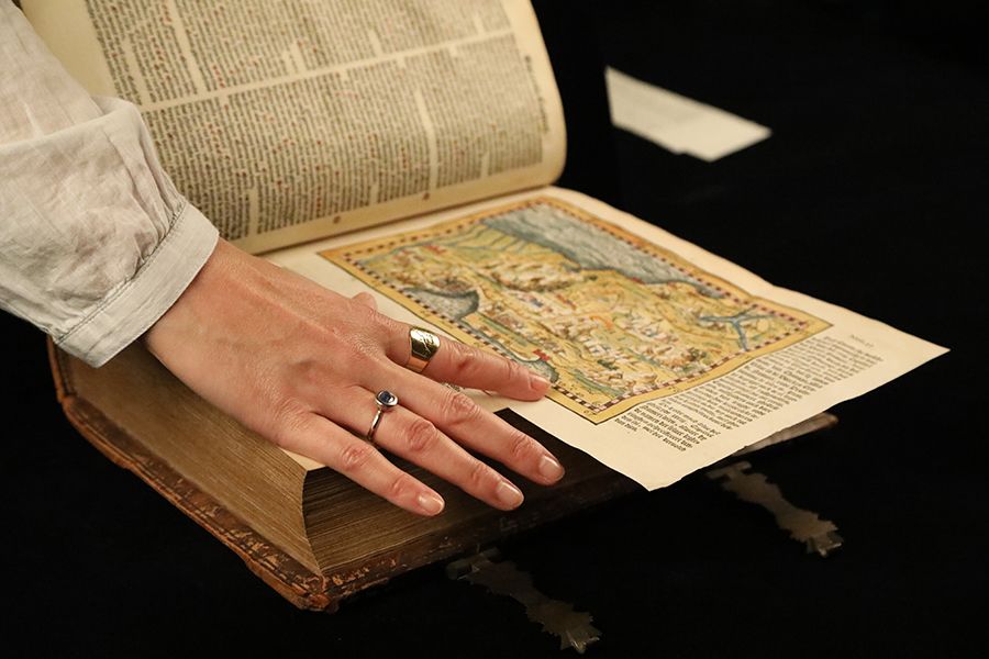 Amélie looking at a small map that has been coloured by hand.