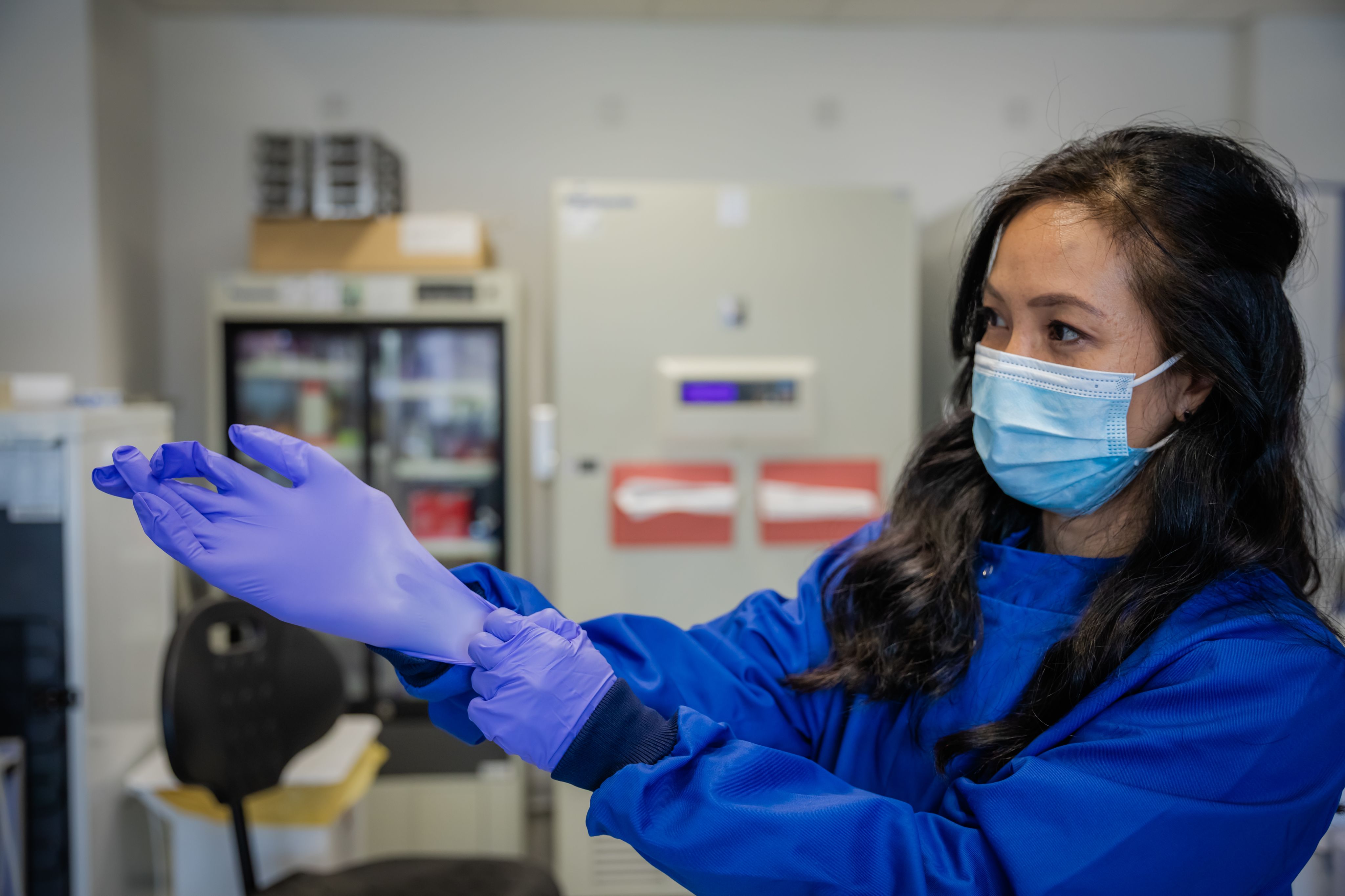 Serena Nik-Zainal putting on gloves in laboratory 