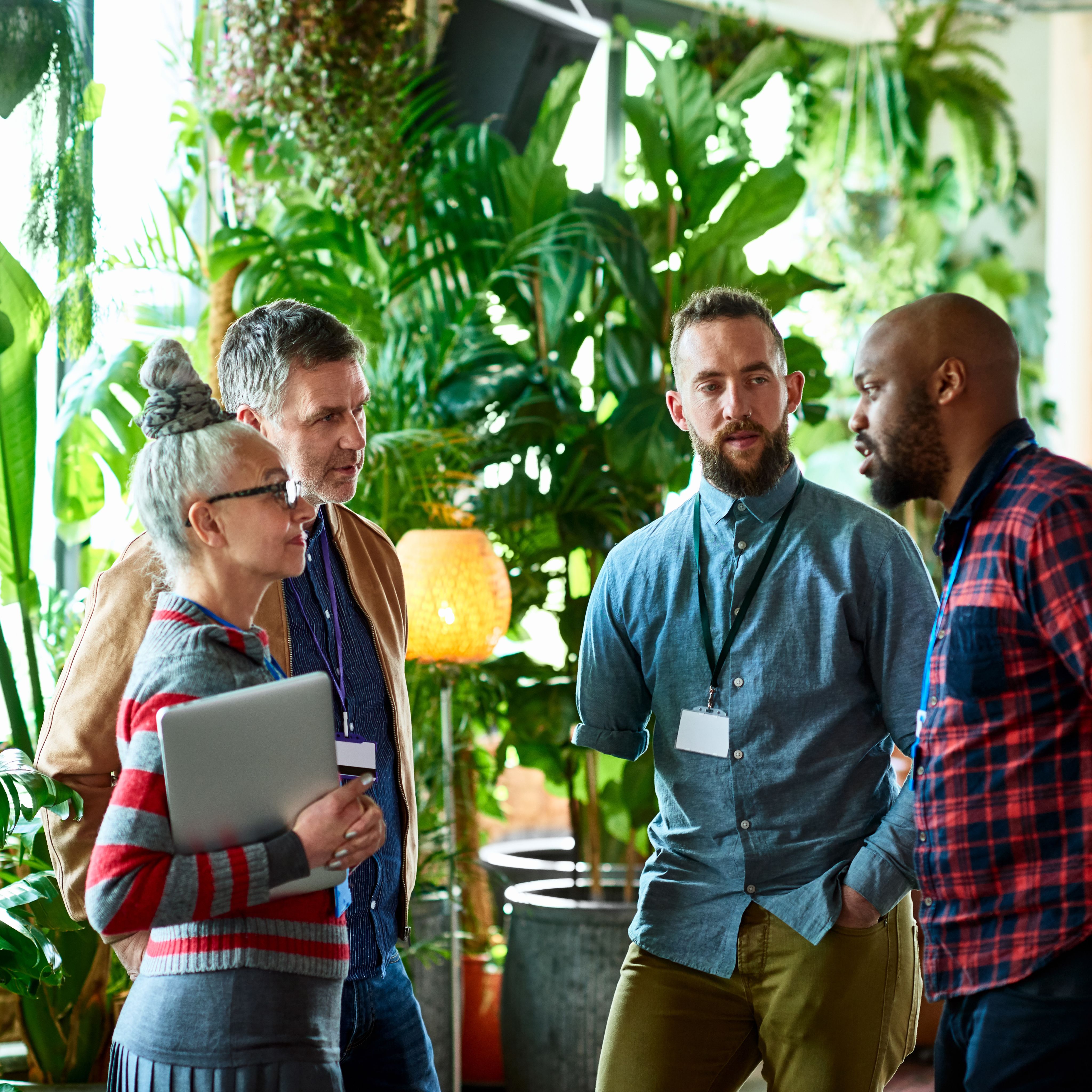 Professionals attending conference chatting in office breakout area, networking, opportunity, business development