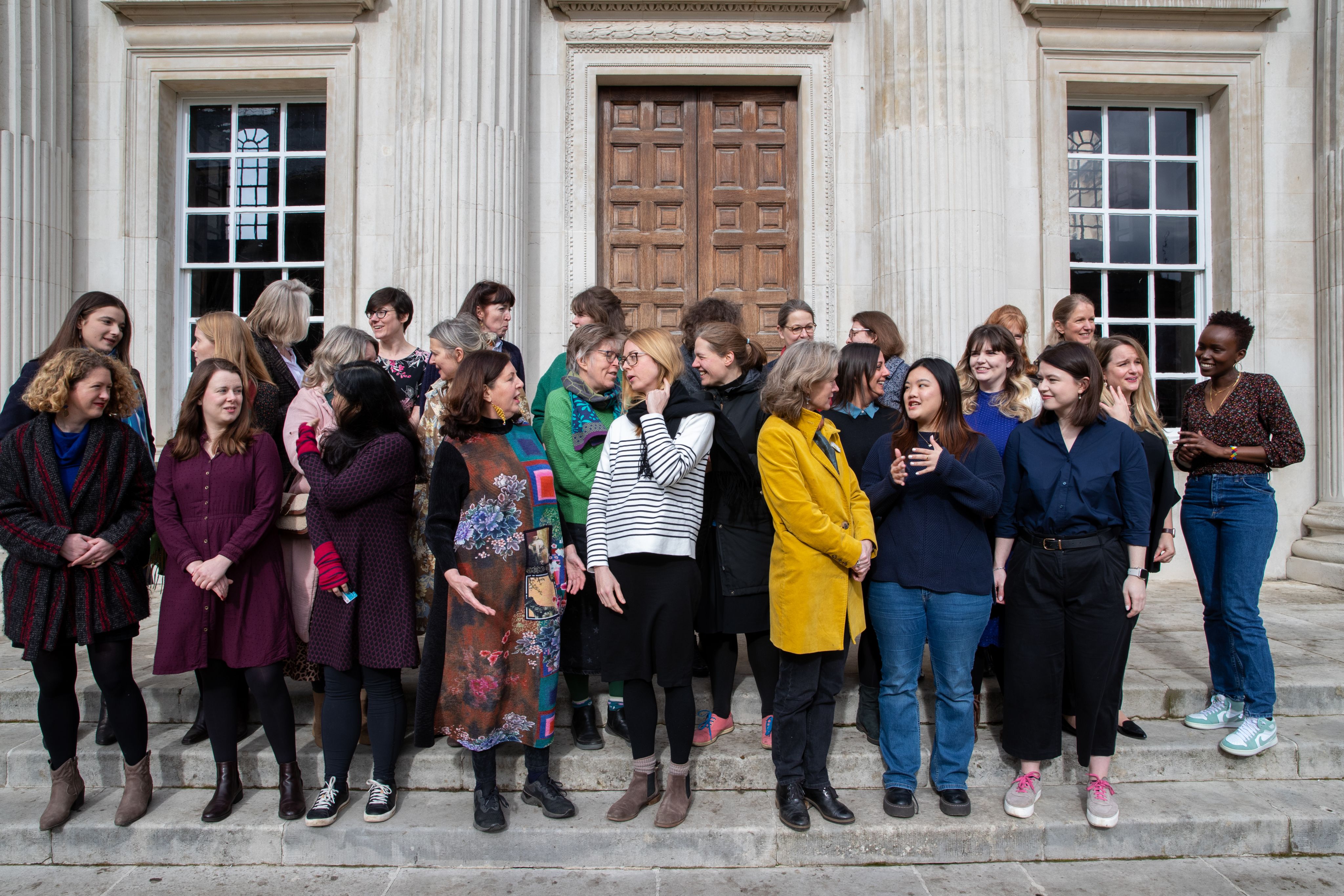 Women of Cambridge University chatting on the steps of Senate House