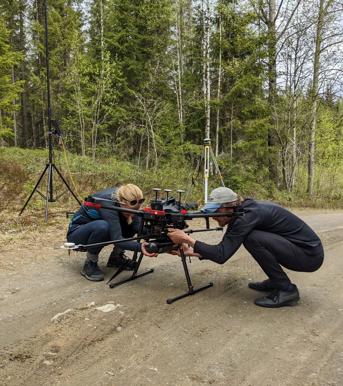 Emily Lines and Harry Owen setting up their scanning drone in a forest in eastern finland