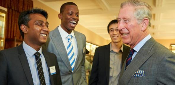 King Charles smiling with a group of Cambridge students