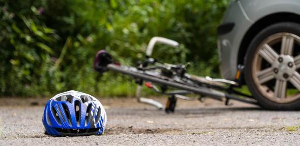 Cycling helmet lying on the floor by a crashed bicycle