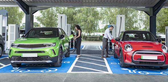 People charging their electric cars at charging station