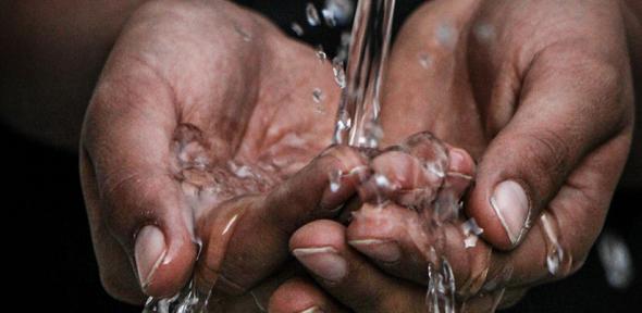 Pouring water on person's hands