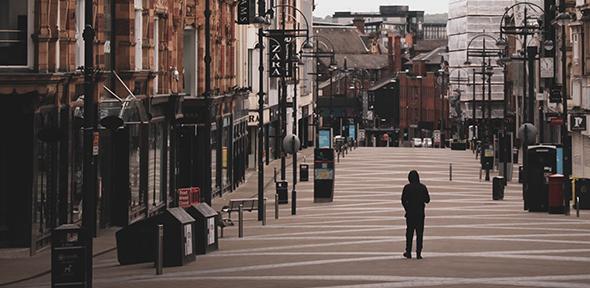 A lone walker in a shopping district of Leeds, UK, during lockdown. 