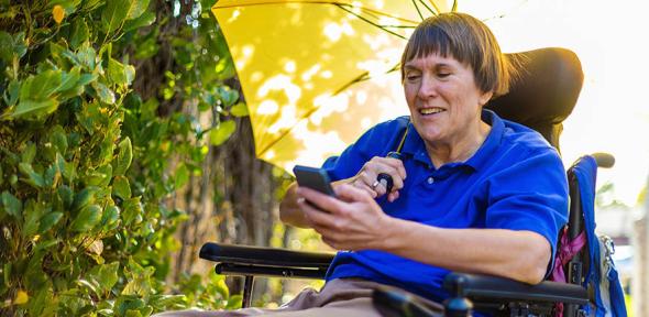 Woman with multiple sclerosis in a wheelchair using her phone