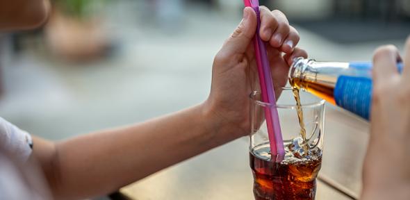 Child's hands pouring a drink into a glass