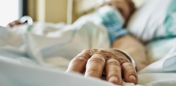 Senior woman wearing face mask lying on hospital bed