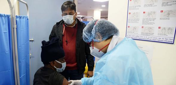 Health care workers administering covid-19 vaccination in New Delhi