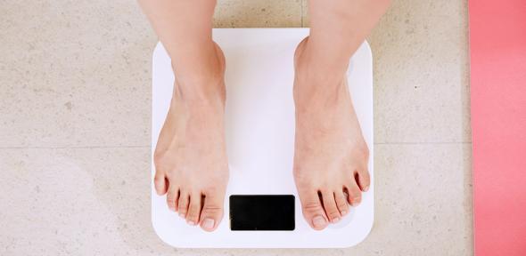 Person standing on white digital bathroom scale