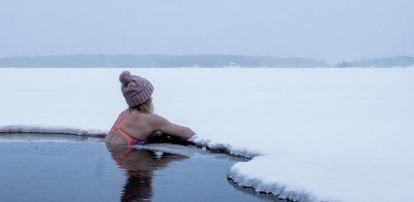 Woman in cold water resting on the ice