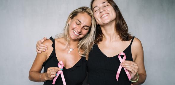Two women holding pink ribbons