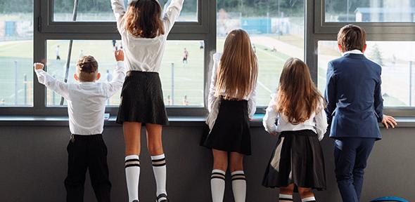 School children watching a sports game from indoors