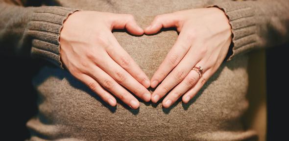 Pregnant person holding her stomach