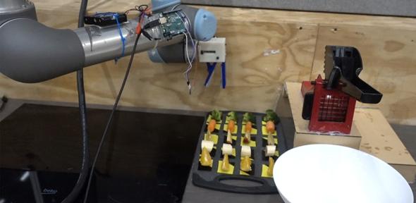 Robot arm reaching for a piece of broccoli