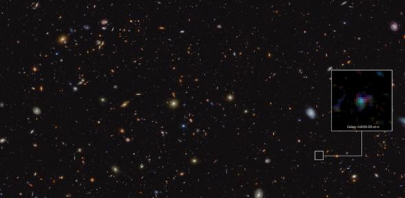 The image shows a deep galaxy field, featuring thousands of galaxies of various shapes and sizes. A cutout indicates a particular galaxy, known as JADES-GS-z6, which was a research target for this result. It appears as a blurry smudge of blue, red and green.