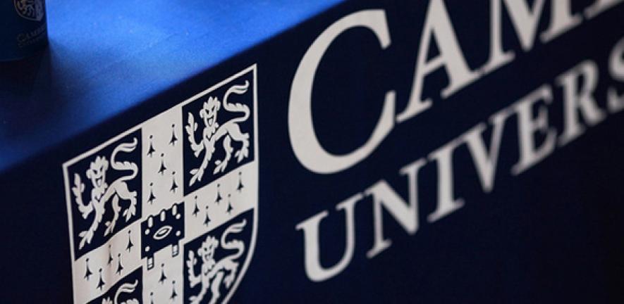 Focus on the University of Cambridge logo on a tablecloth.