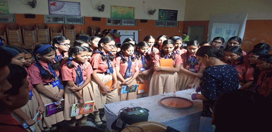 Schoolgirls in Mumbai observing a surface tension experiment