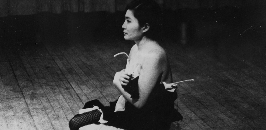YOKO ONO LOOKING FOR...CURATOR TALK Yoko Ono performing Cut Piece [1964] at Carnegie Recital Hall, NYC. March 25, 1965. Copyright Minoru Niizuma C Yoko Ono
