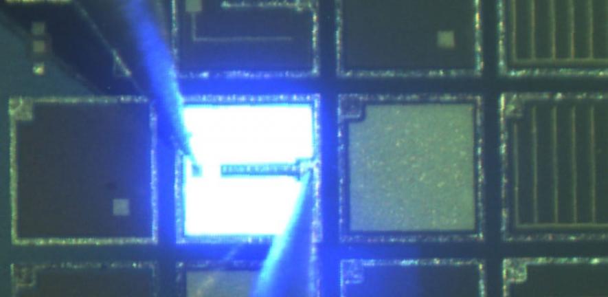 An LED emitting light on a 6-inch silicon wafer.