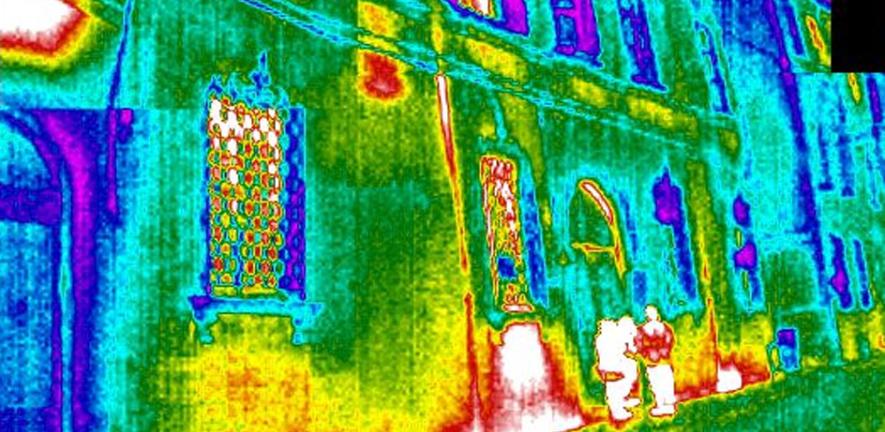 Thermal image of two people standing outside a building. The study found that in many European countries, including the UK, predicted energy usage in homes bears little resemblance to the amount used in practice.
