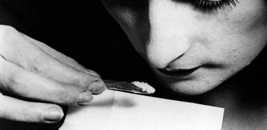 A close up of a young woman snorting cocaine during the 1920s