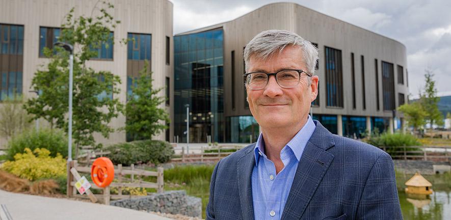 Professor Martin Bennett standing outside the Victor Phillip Dahdaleh Heart and Lung Research Institute