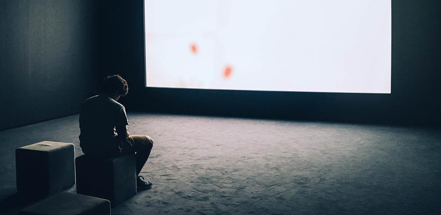 A man sitting in front of a screen