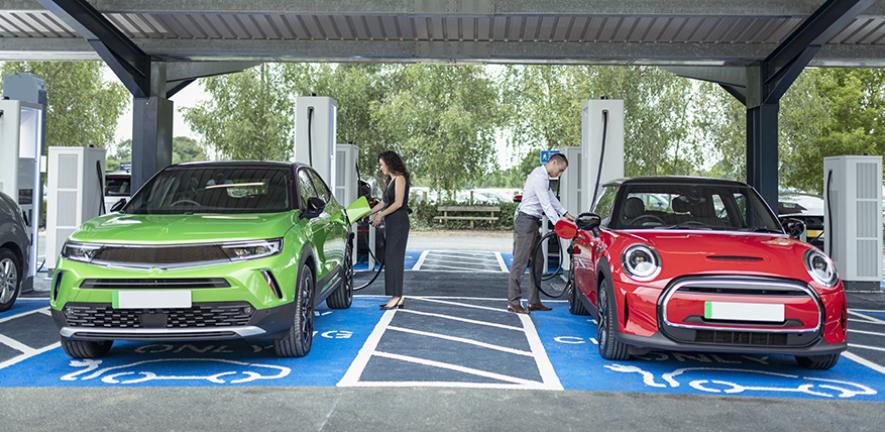 People charging their electric cars at charging station