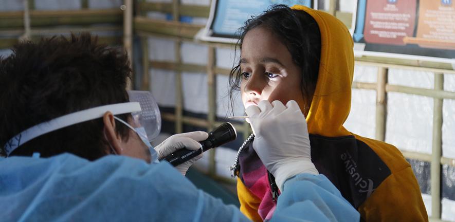 UK Emergency Medical Team paediatric nurse checks a girl for symptoms of Diphtheria in the Kutapalong refugee camp, Bangladesh
