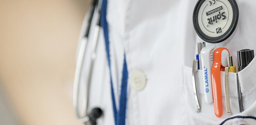 Doctor's white coat with stethoscope and pens