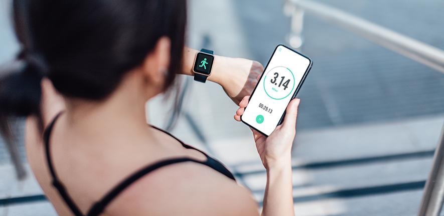 Woman checking her smart watch and mobile phone after run