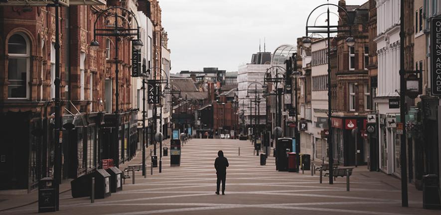 A lone walker in a shopping district of Leeds, UK, during lockdown. 