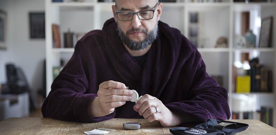 Man using blood sugar measurement device to monitor diabetes - stock photo