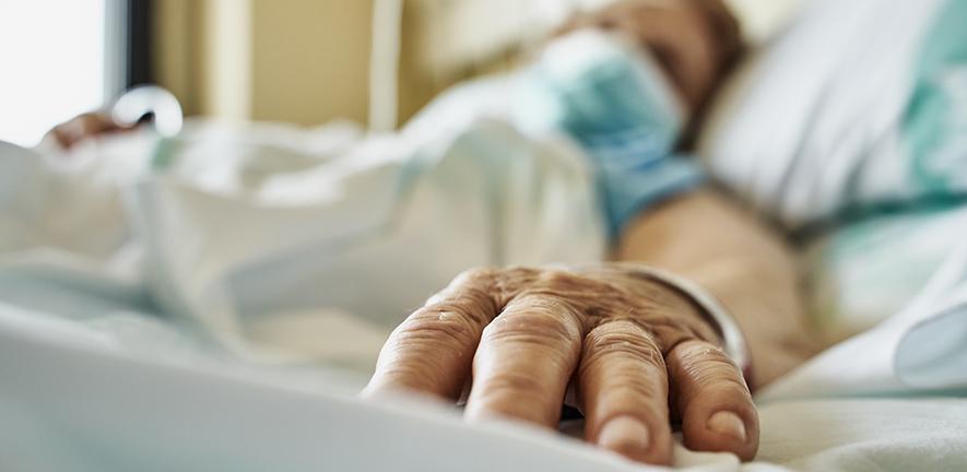 Senior woman wearing face mask lying on hospital bed